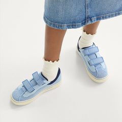 hover | A child modeling The Kids Strap Sneaker in Berry Blue. 