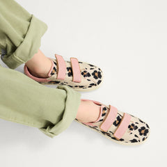 hover | A child modeling The Kids Strap Sneaker in Cat Blush. 