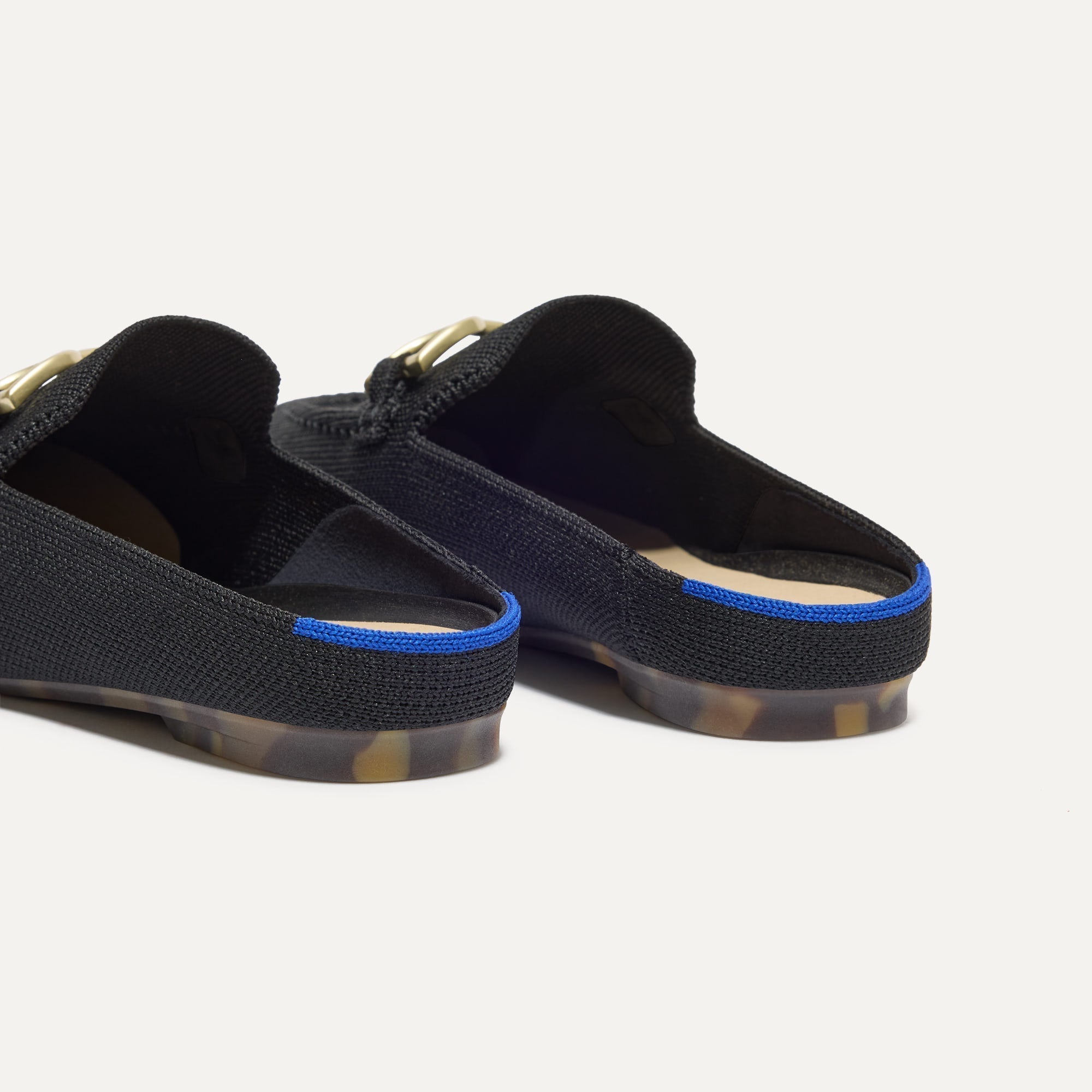 Close up of the heel of The Double Bit Loafer Mule in Black, with Rothy's signature blue halo. 