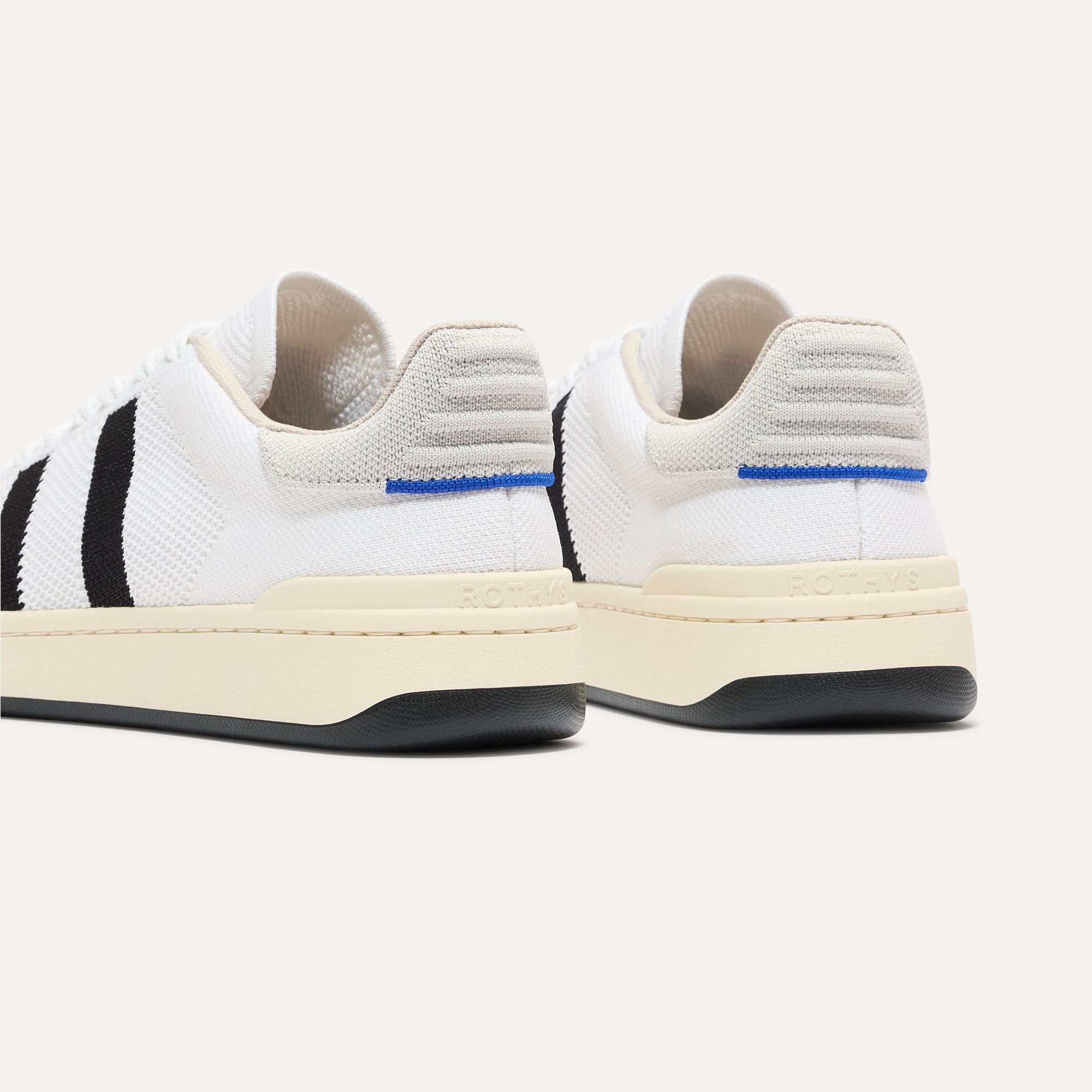 Close up of the heel of The Men's Court Sneaker in Black Drift, with Rothy's signature blue halo. 