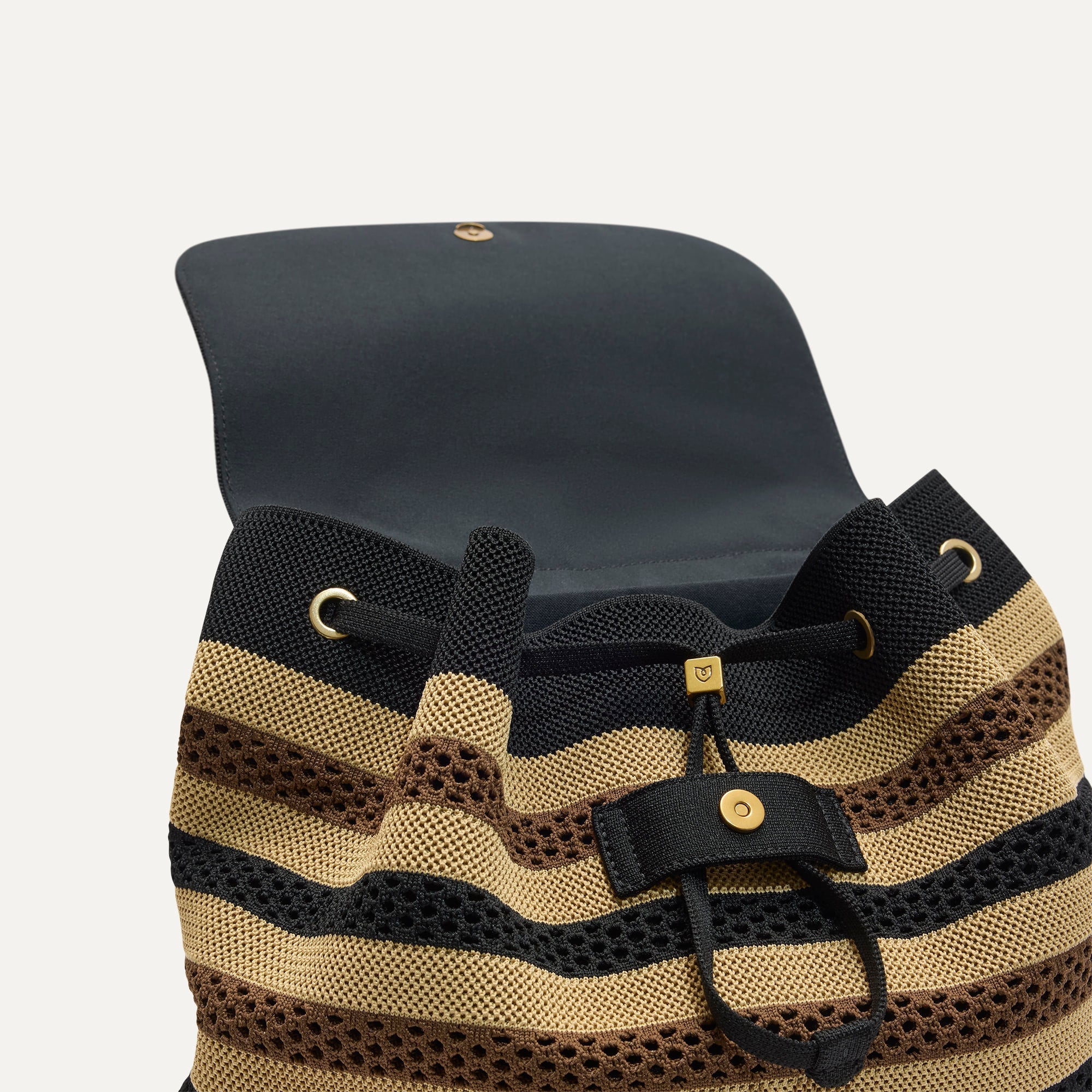 A close up of The Cinch Backpack in Mocha Stripe Crochet showing the drawstring closure.