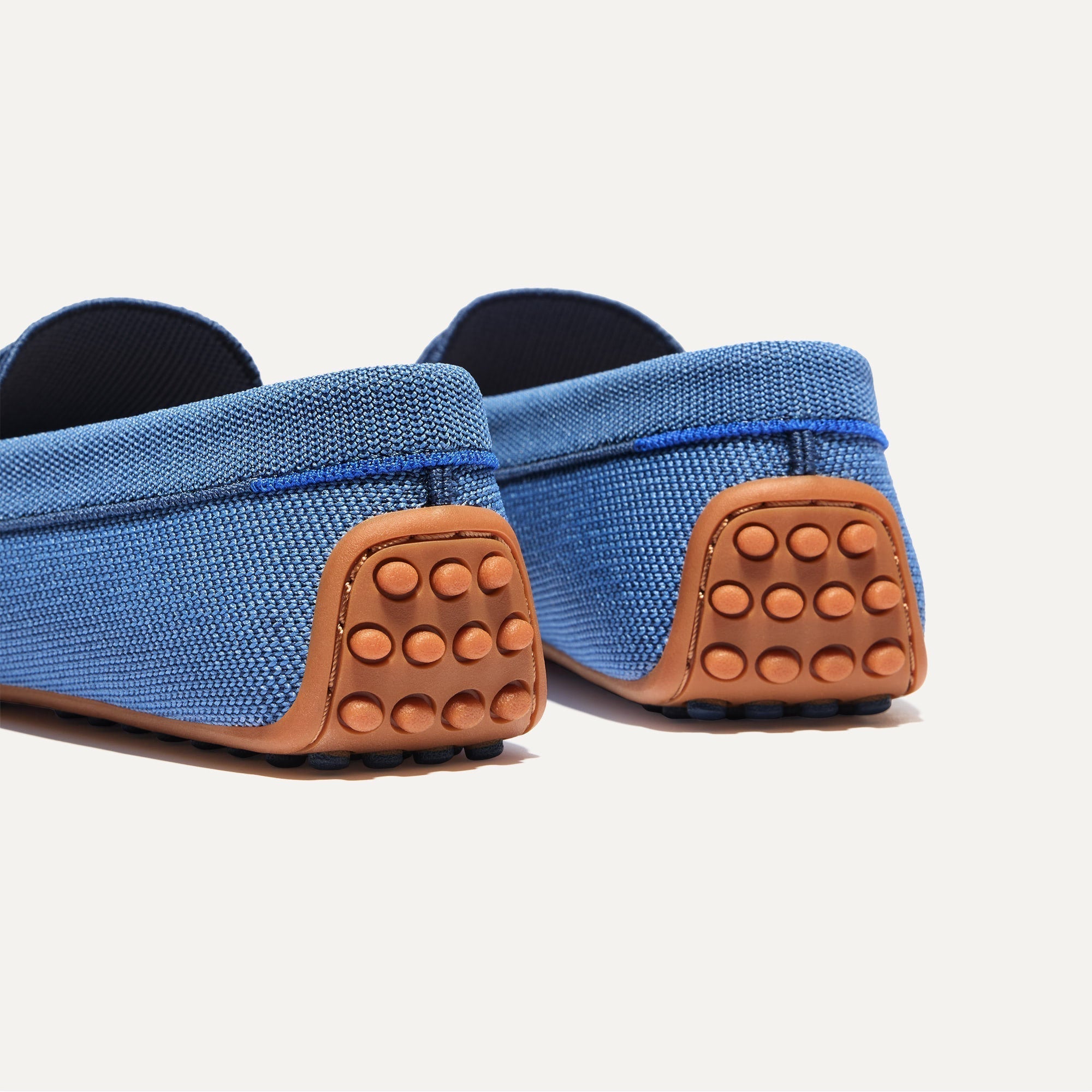 Close up of the heel of The Daily Driver in Blue Sea, with raised peg outsoles and Rothy's signature blue halo. 