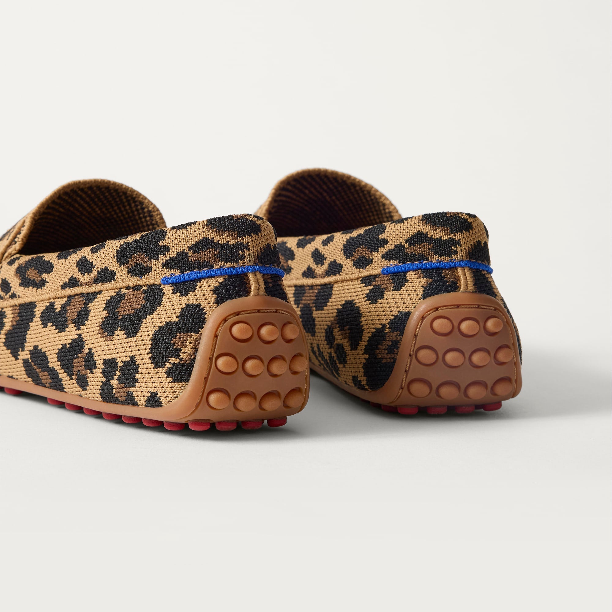 Close up of the heel of The Daily Driver in Caramel Cat, with raised peg outsoles and Rothy's signature blue halo. 