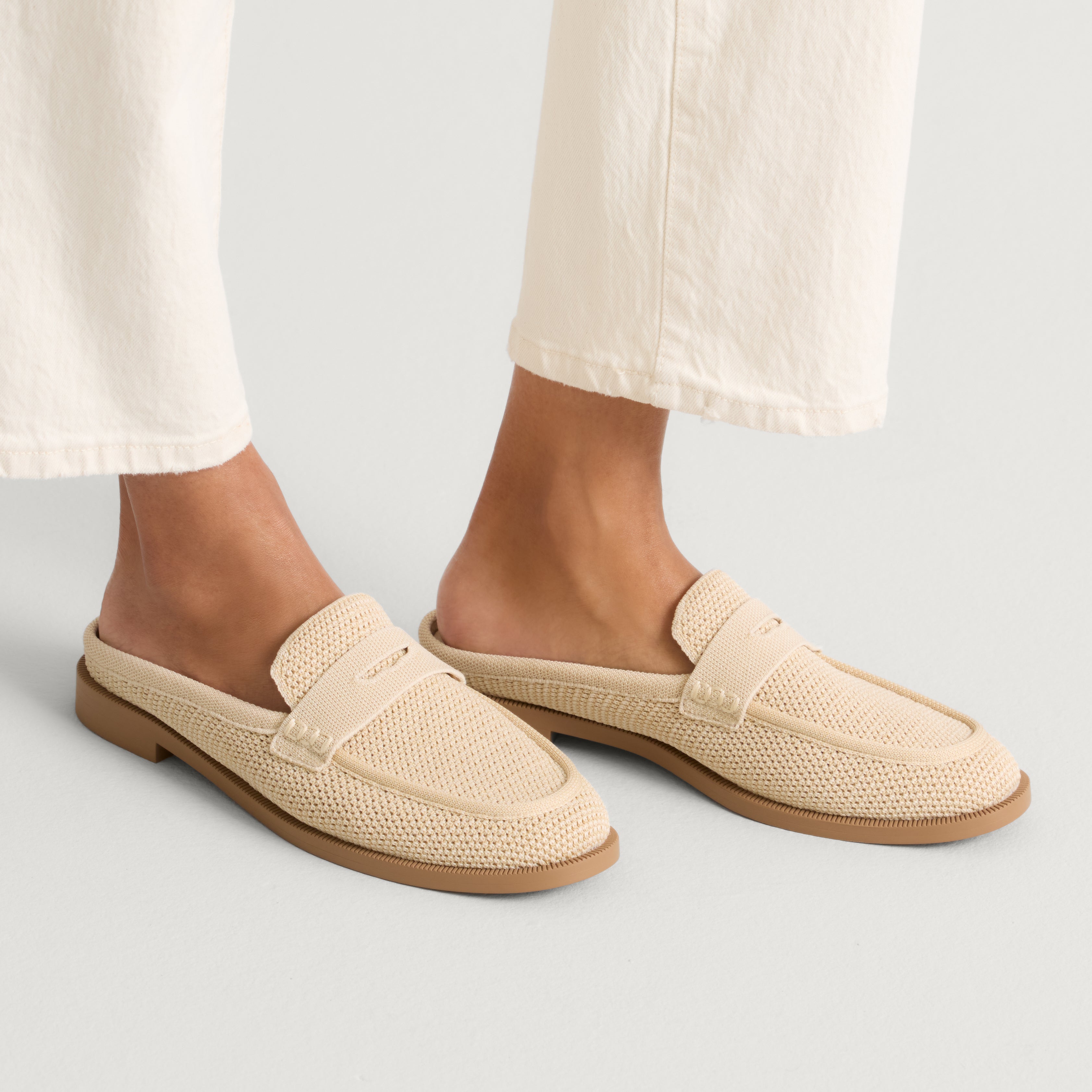 hover | Model wearing The Penny Loafer Mule in Sandstone Raffia-Knit.