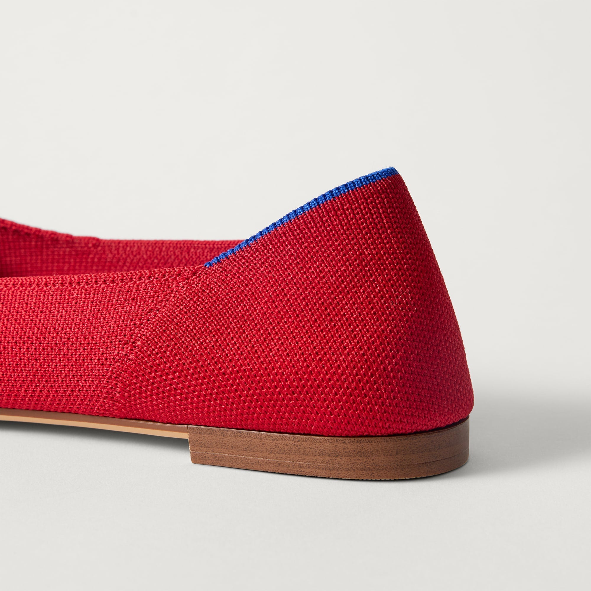 Close up of the heel of The Point III in Cherry, with Rothy's signature blue halo. 