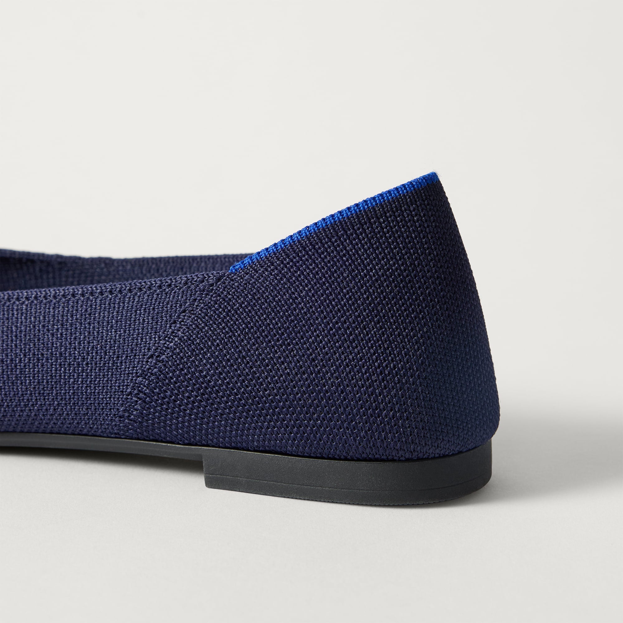 Close up of the heel of The Point III in Navy, with Rothy's signature blue halo. 