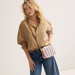 hover | The Crossbody Camera Bag in  Watermelon Market Stripe worn as a crossbody by a model.