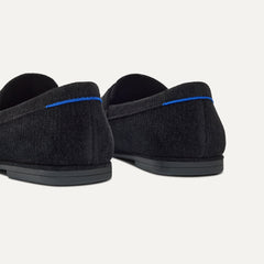 Close up of the heel of The Ravello Penny Loafer in ReVelvet™ Black, with Rothy's signature blue halo on the pull tab.