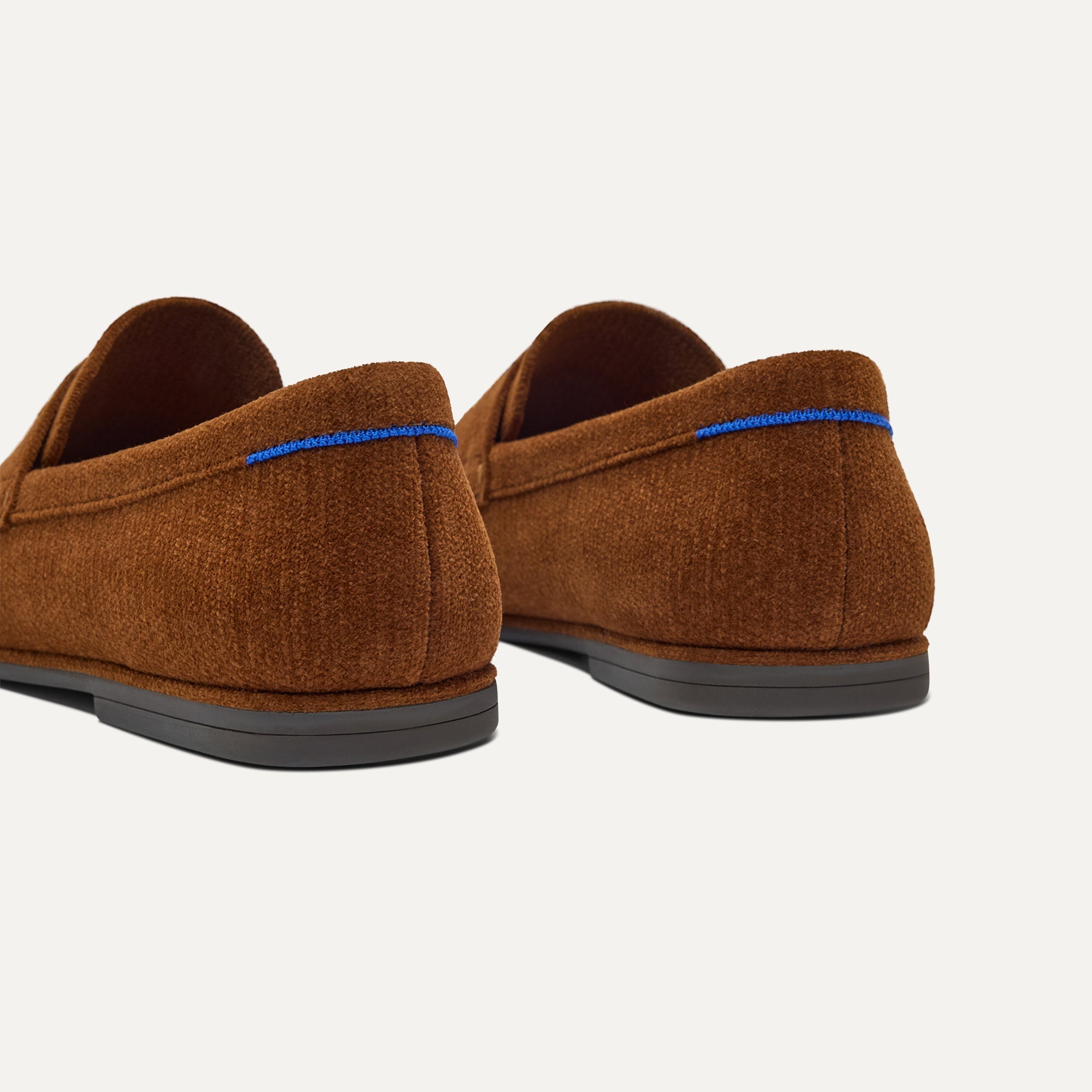 Close up of the heel of The Ravello Penny Loafer in Russet, with Rothy's signature blue halo on the pull tab.