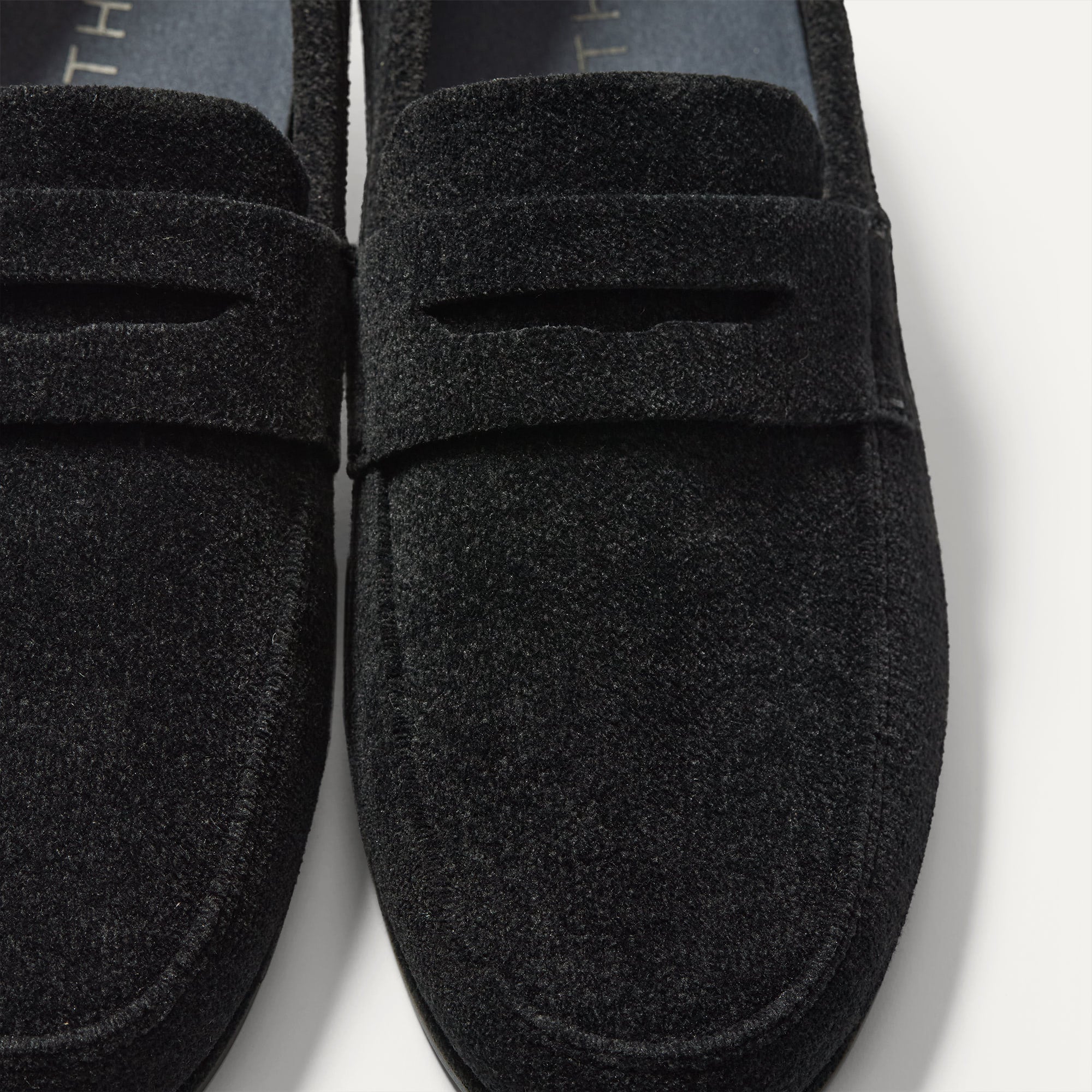 Close up of the vamp and penny keeper detail on The Ravello Penny Loafer in ReVelvet™ Black.