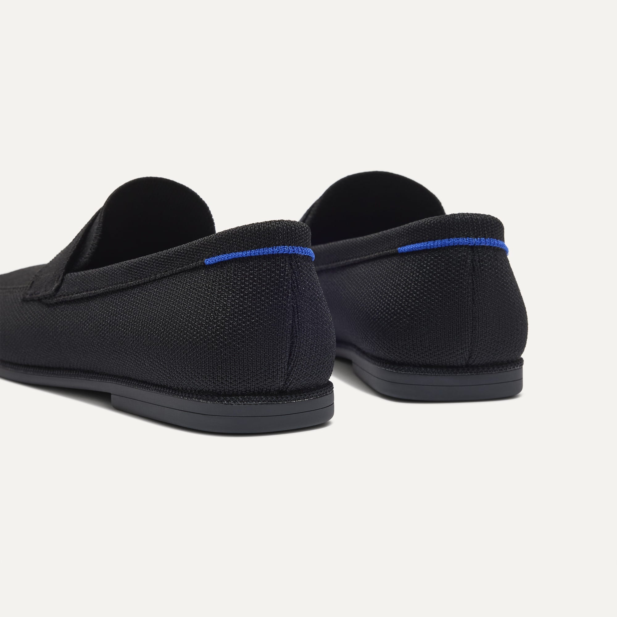 Close up of the heel of The Ravello Penny Loafer in Black, with Rothy's signature blue halo on the pull tab.