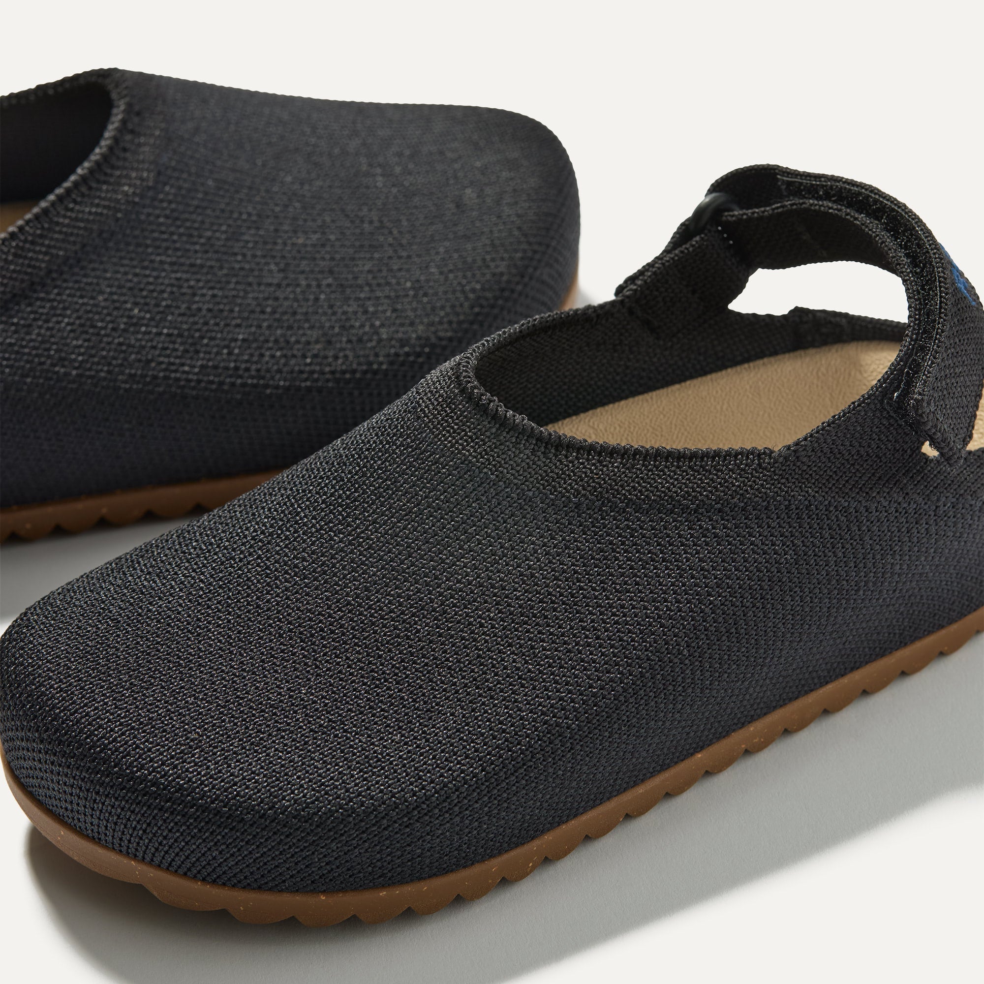 Close up of the rounded topline of The Kids Clog in Black. 