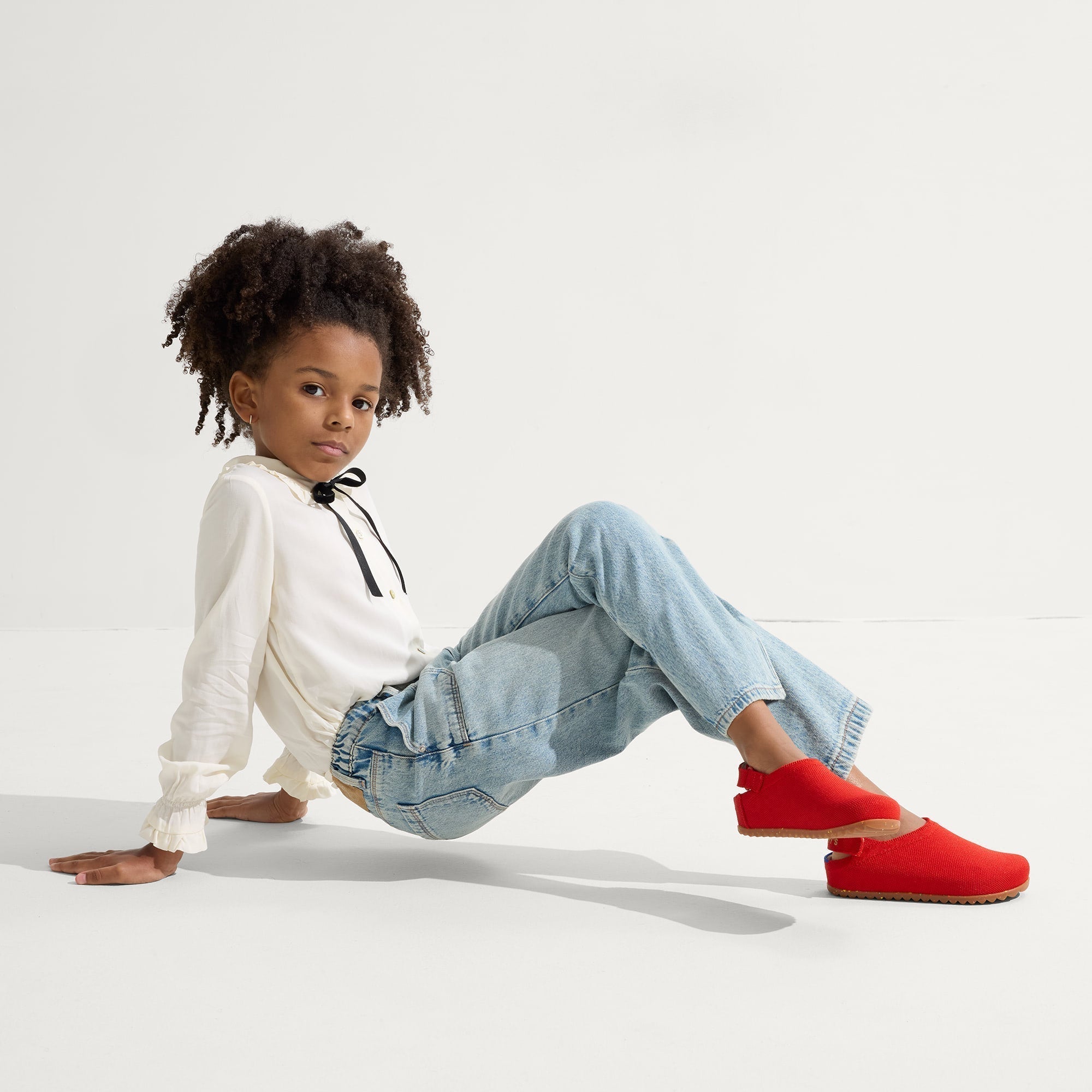 Child wearing The Kids Clog in Firetruck Red. 