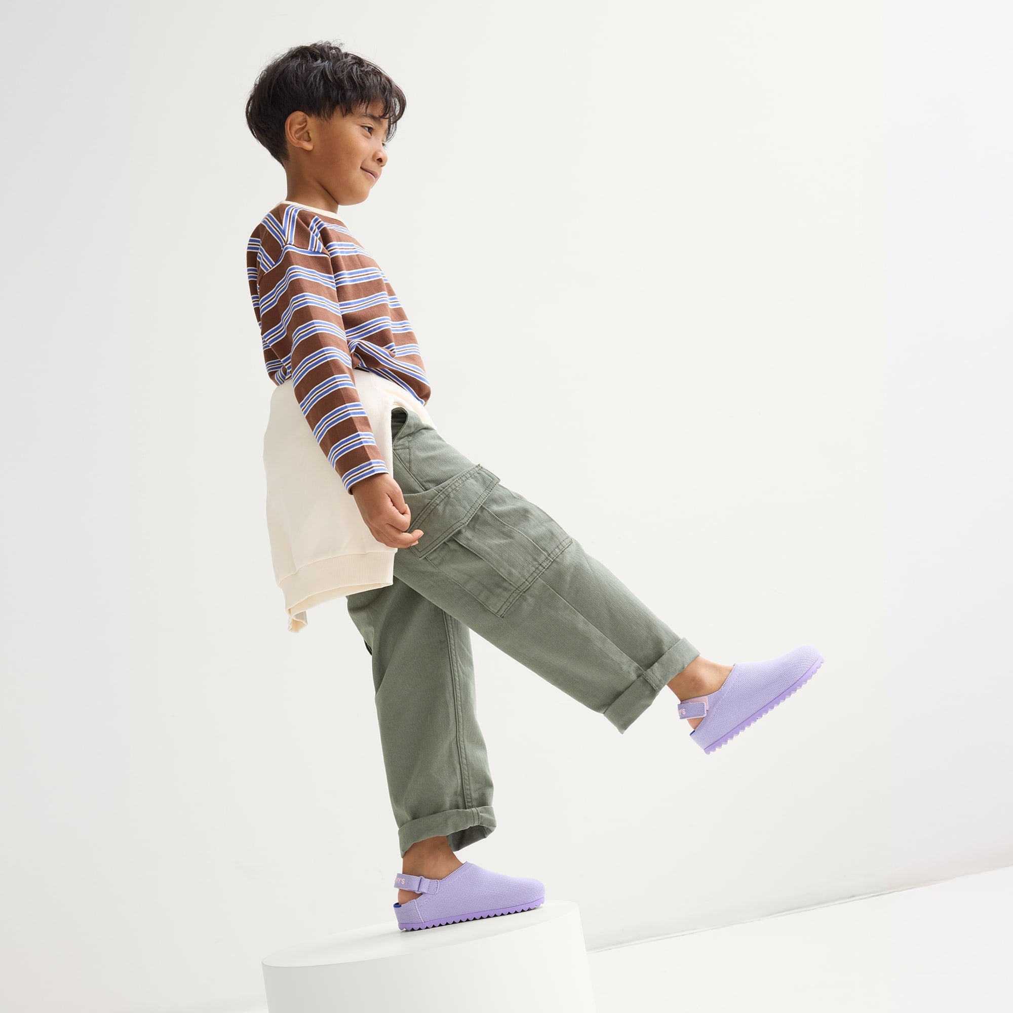Child wearing The Kids Clog in Soft Orchid. 