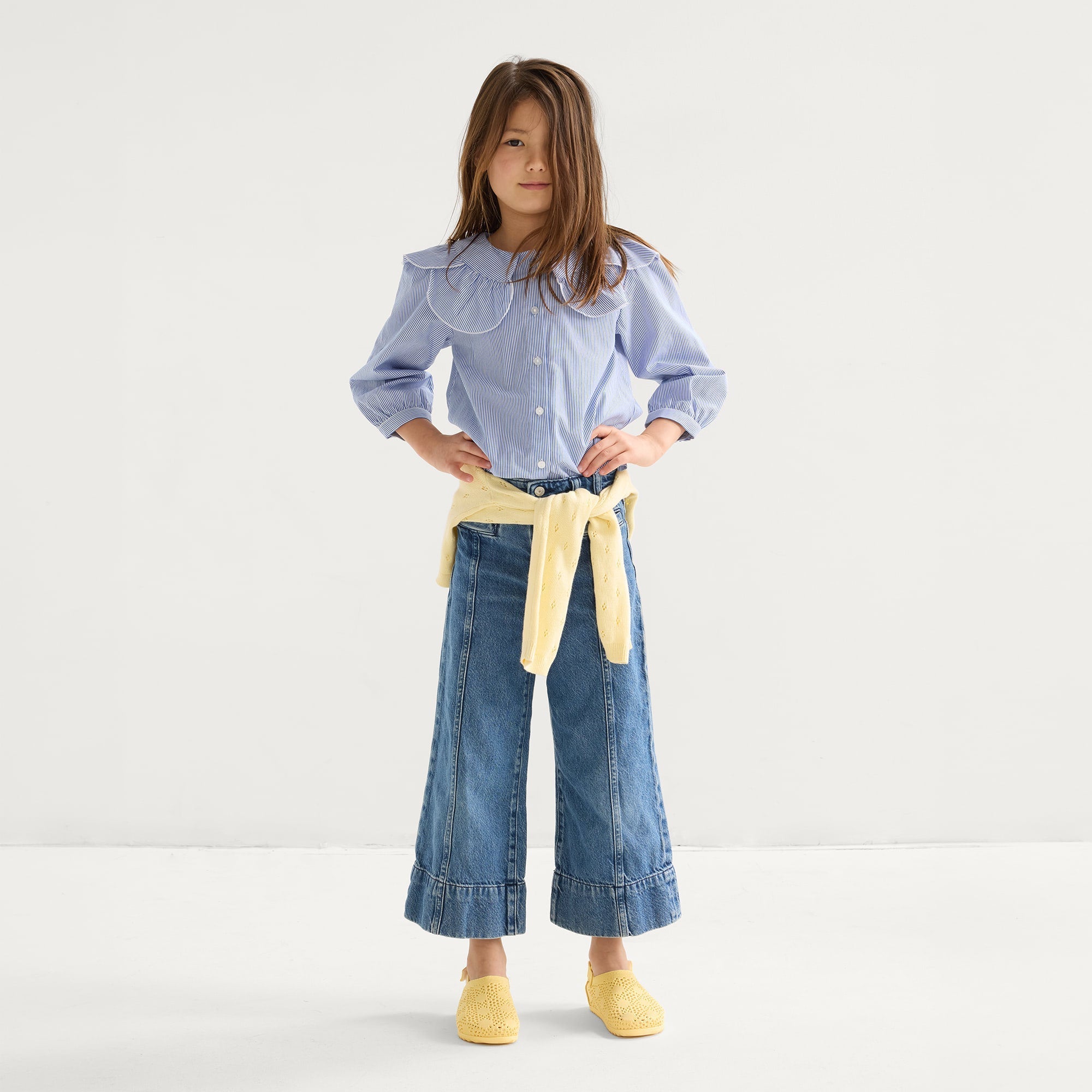model | Alternate view of a child wearing The Kids Clog in Sunny Crochet. 