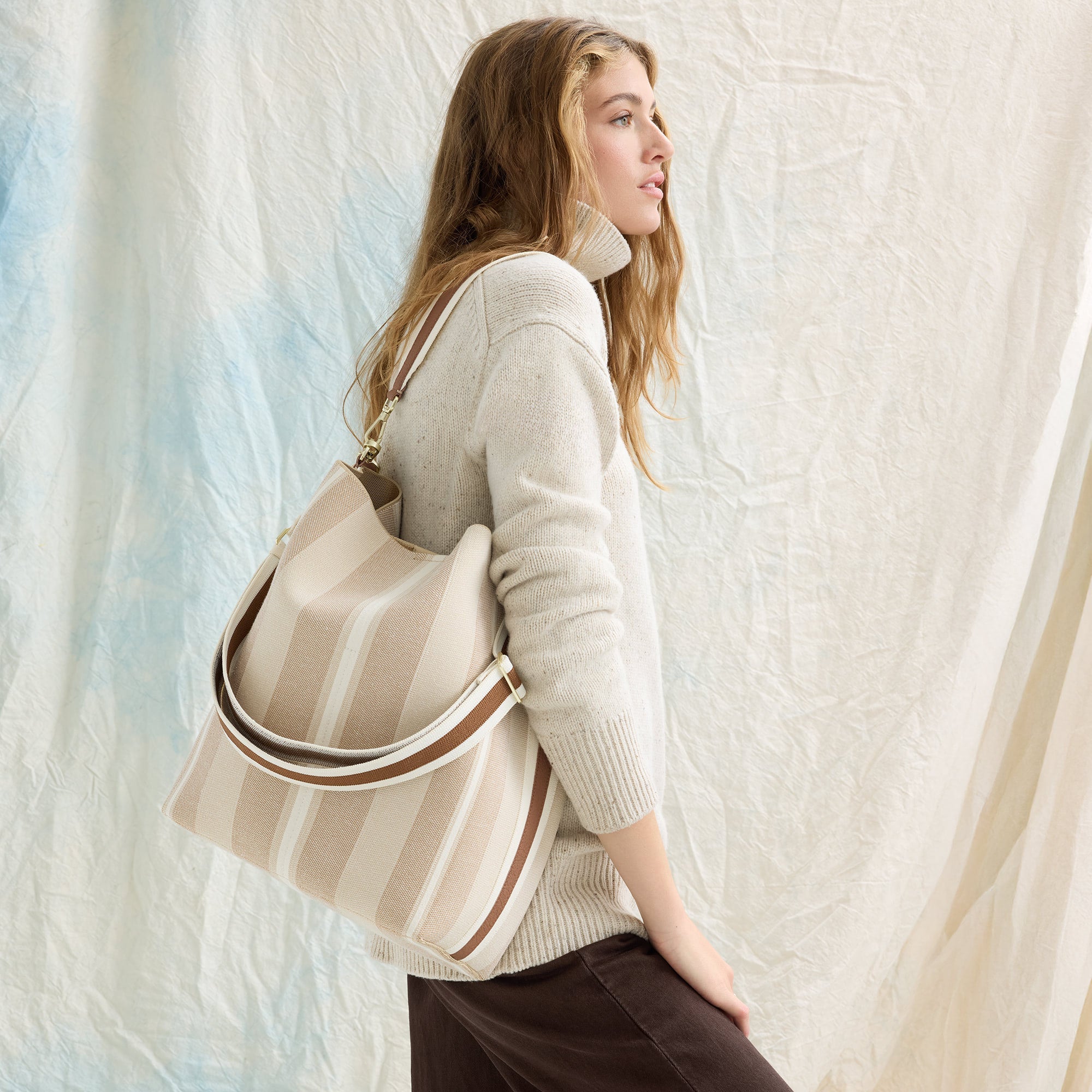 hover | An image of The Bucket Bag in Oat Latte shown worn on model.