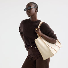 hover | The Classic Tote in Buttercream, worn over the shoulder by a model, shown from the side.
