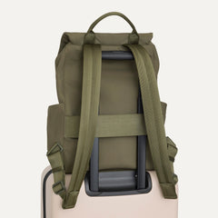 The Travel Cinch Backpack in Forest shown from the back, shown attached to a rolling suitcase using the wrap-around band.