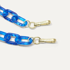 A close-up of The Shoulder Strap in Cobalt Chain, focusing on the end snap hooks. 
