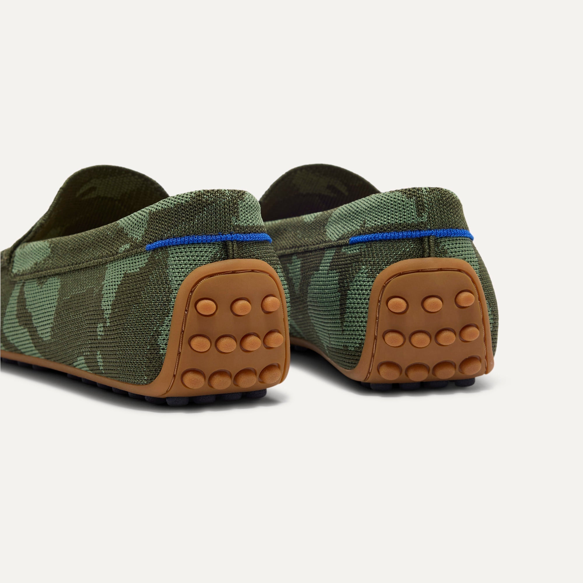 Close up of the heel of The Men's Daily Driver in Forest Camo, with raised peg outsoles and Rothy's signature blue halo. 