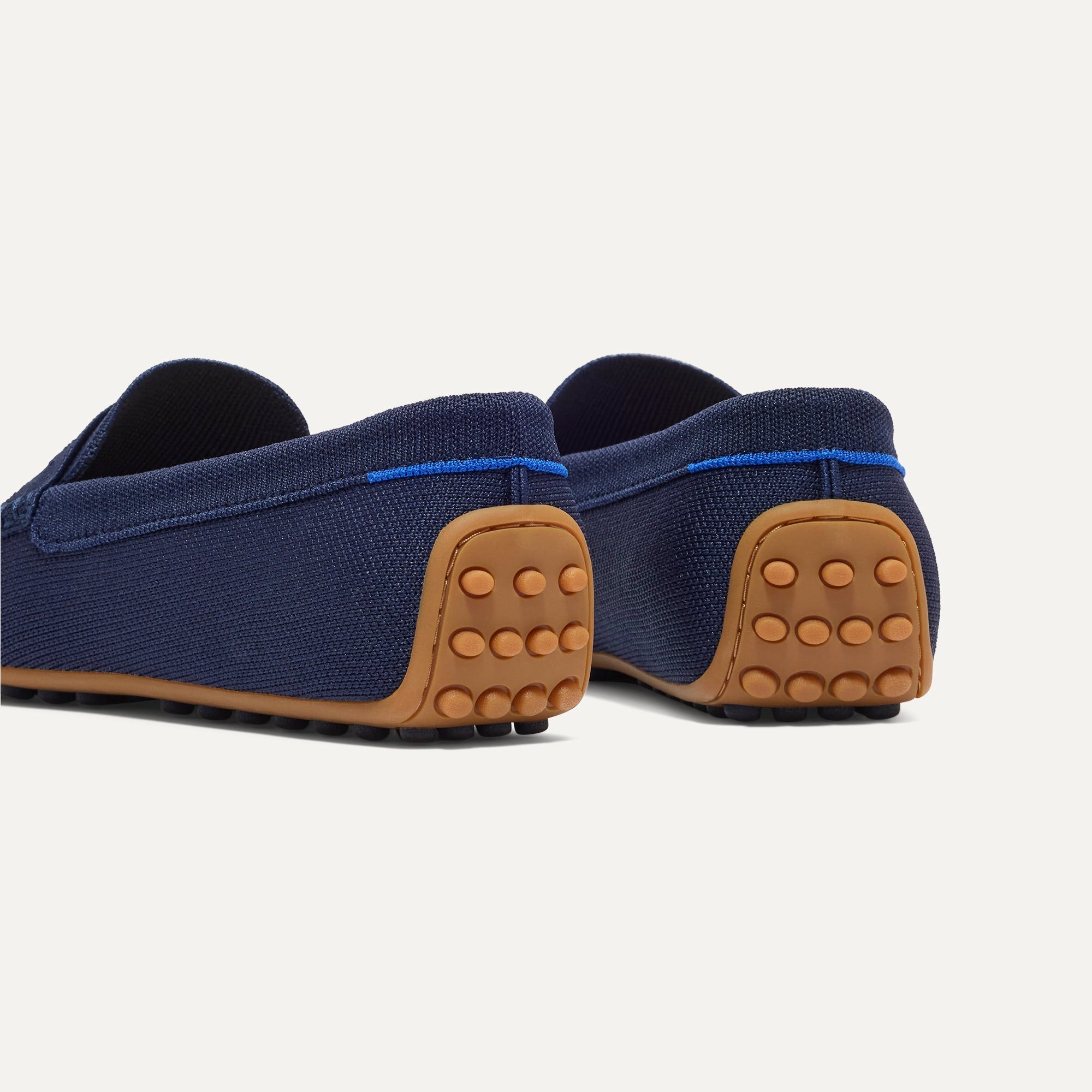 Close up of the heel of The Men's Daily Driver in Nautical Navy, with raised peg outsoles and Rothy's signature blue halo. 