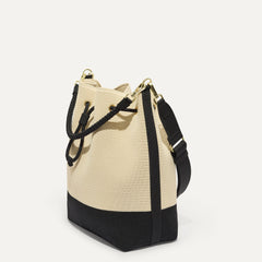 The Cinch Bucket Bag in Black and White Raffia-Knit shown from the side.