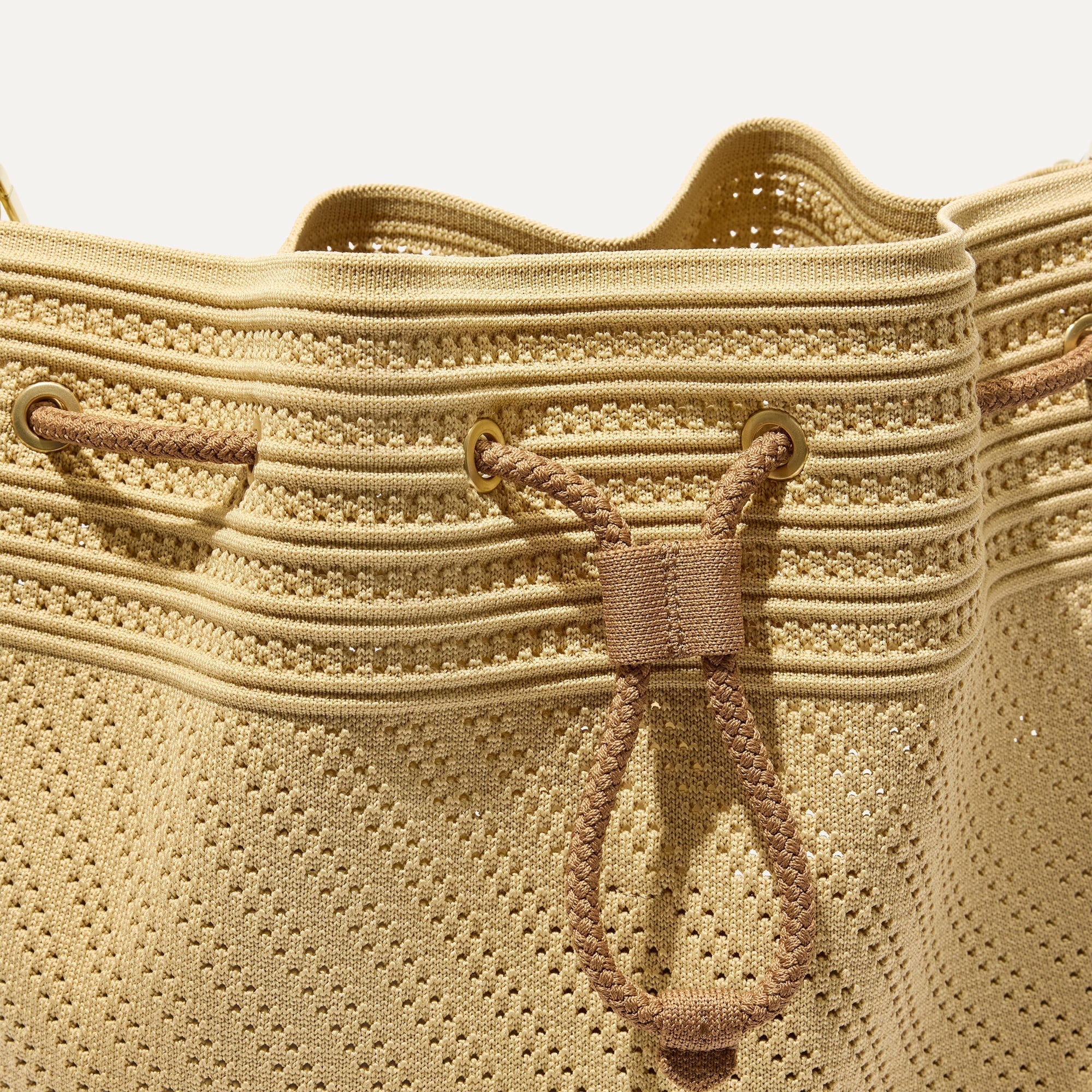 A close up of The Cinch Bucket Bag in Brown Butter Crochet showing the drawstring closure.