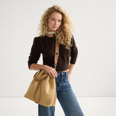hover | Model wearing The Cinch Bucket Bag in Brown Butter Crochet shown from the front.