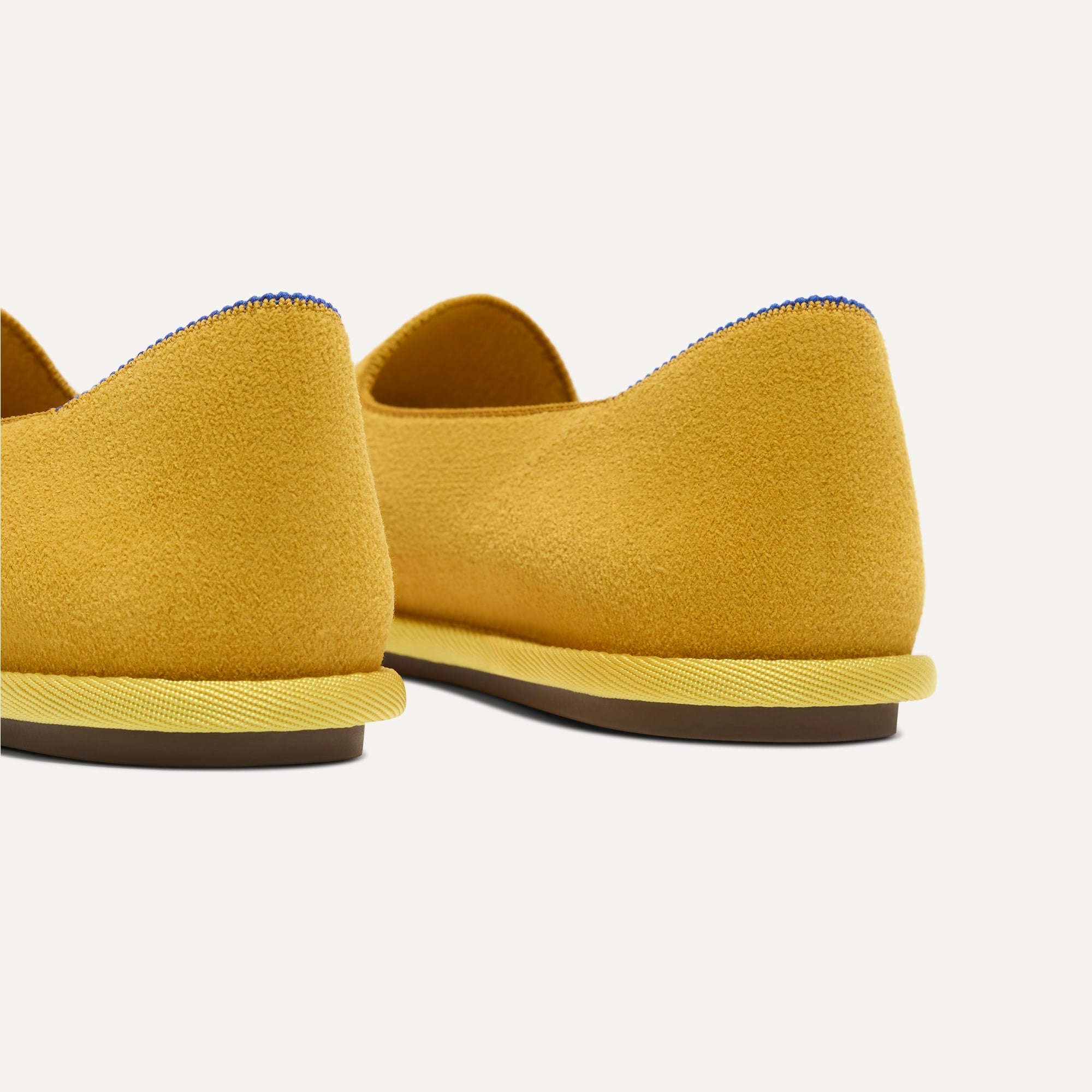 Close up of the heel of The Cruiser Loafer in ReVelvet Saffron, with Rothy's signature blue halo. 