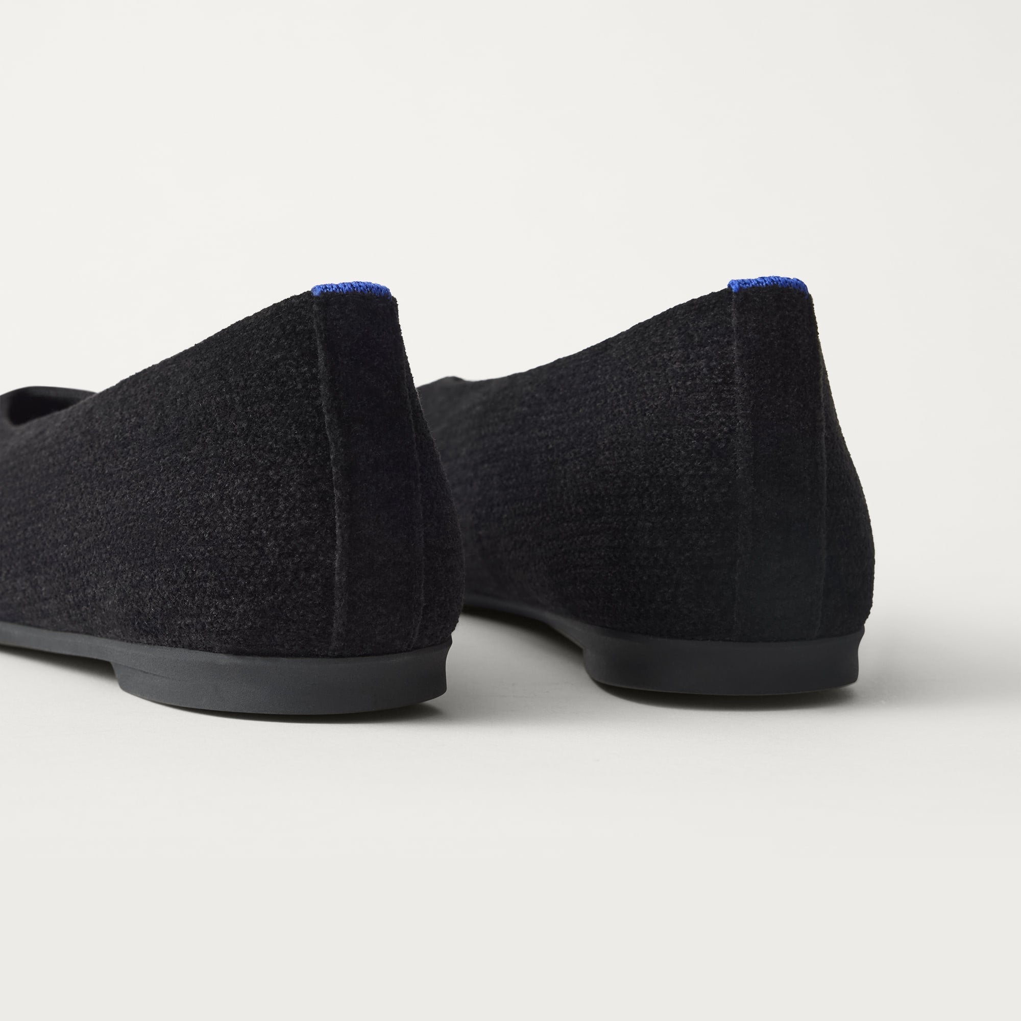 Close up of the heel of The Max Square Ballerina in ReVelvet Black with Rothy's signature blue halo.