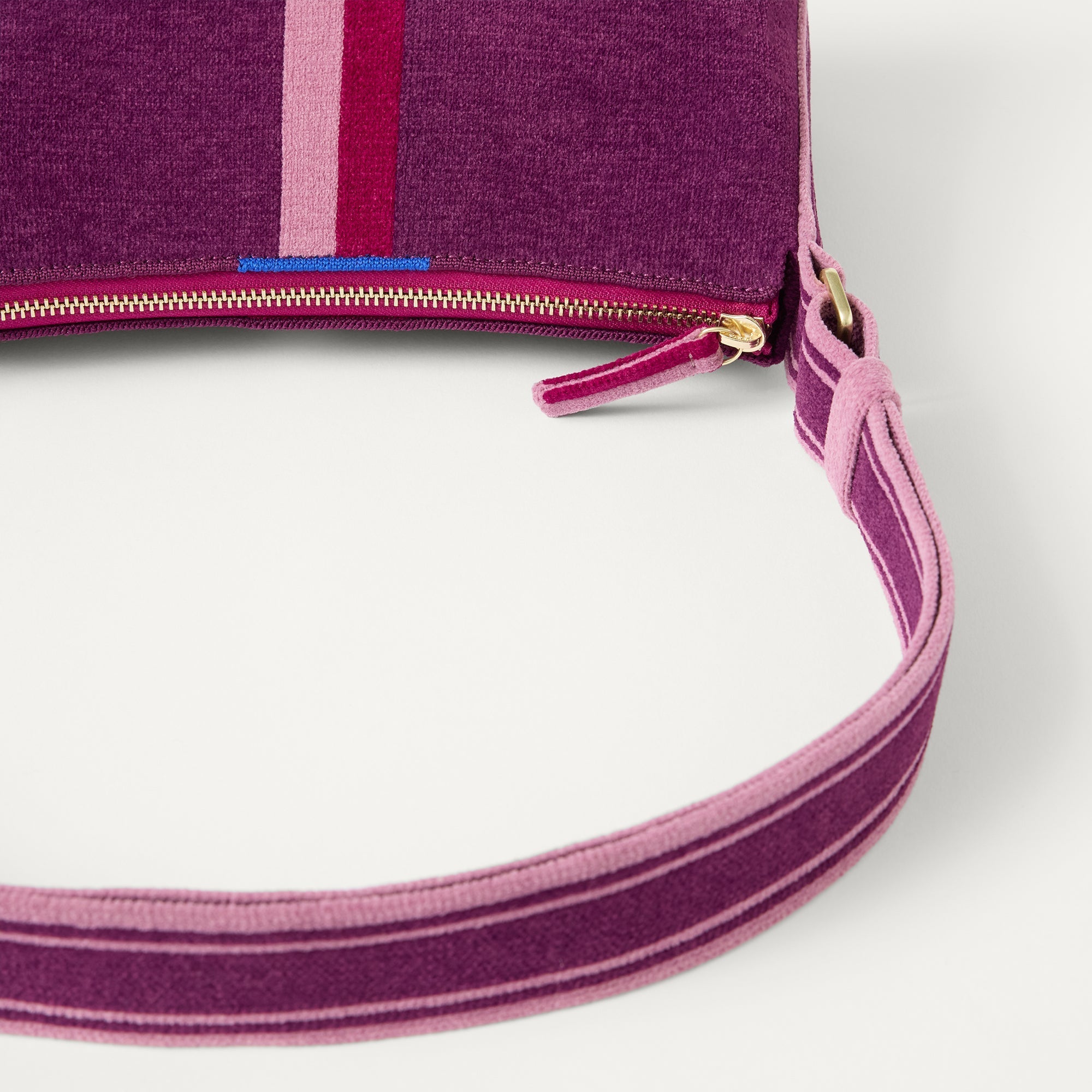 A closeup of The Casual Crossbody in ReVelvet Orchid, focusing on the crossbody strap. 
